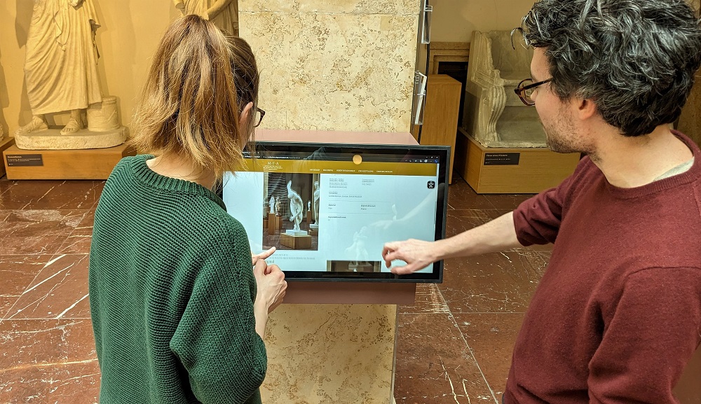 Ein junger Mann und eine junge Frau stehen vor einer Medienstation im Museum